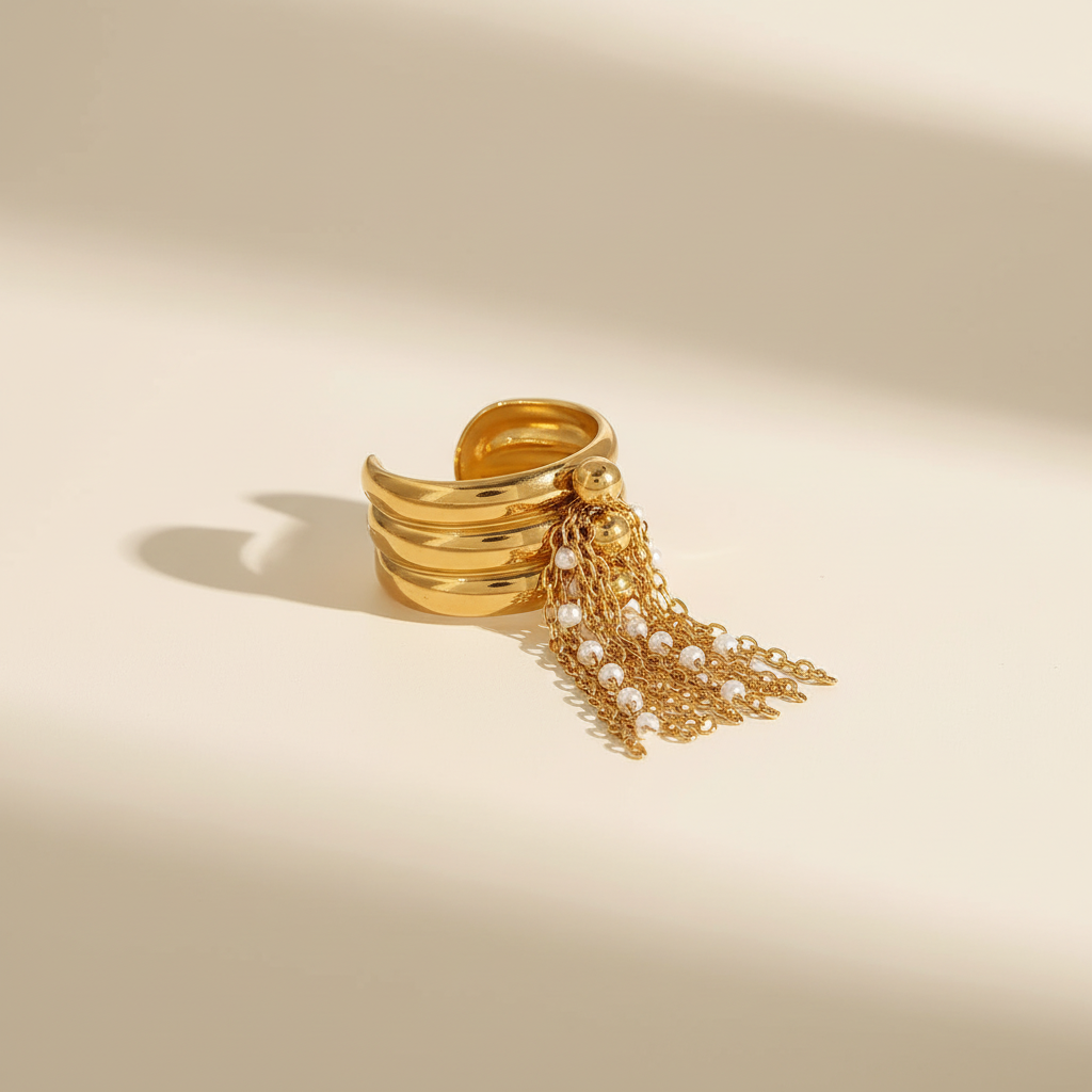 Bague dorée à chaînes et perles fond beige