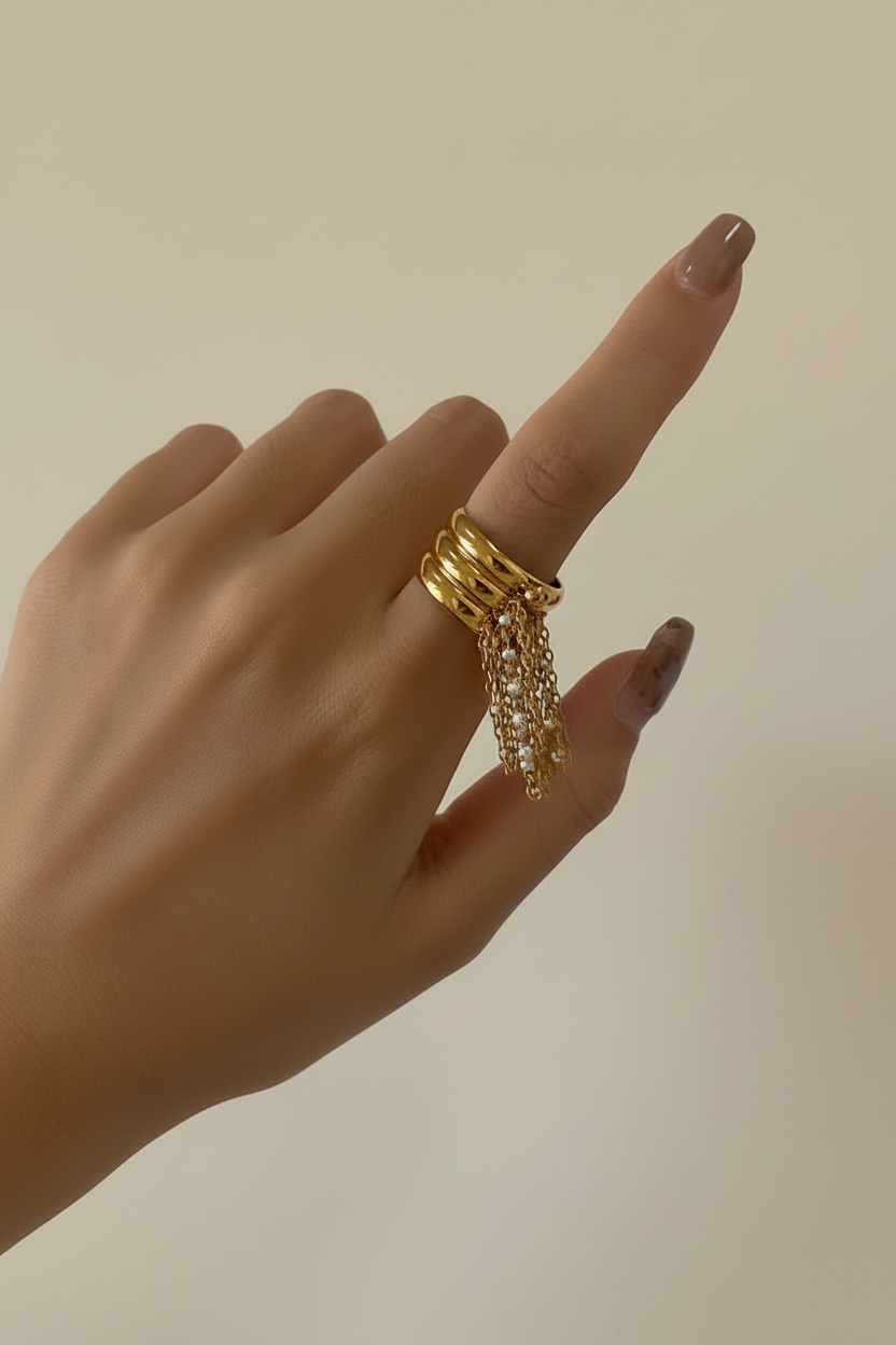 Bague dorée doigts courbés fond beige