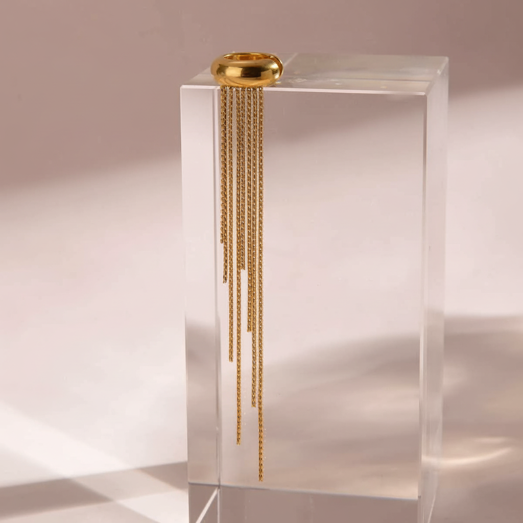 Ear cuff doré sur cube transparent - fond rose pâle